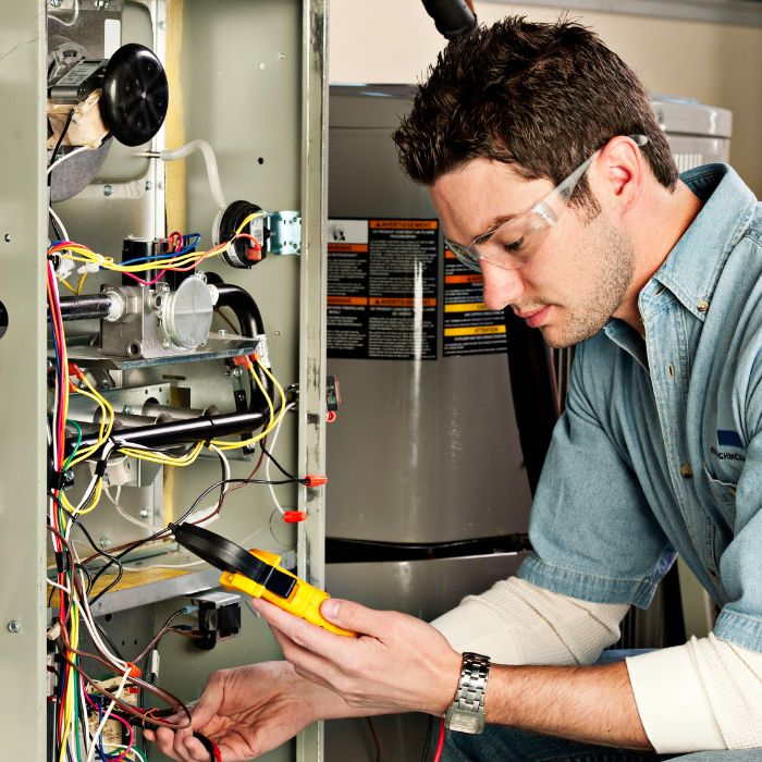 A service technician repairing a furnace at a customers home